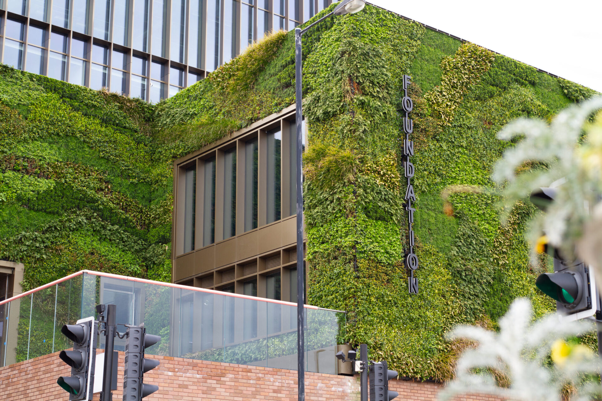Fachada verde del edificio Foundation en Manchester, ejemplo de espacios sostenibles y Real Estate verde que redefine la arquitectura urbana con vegetación.