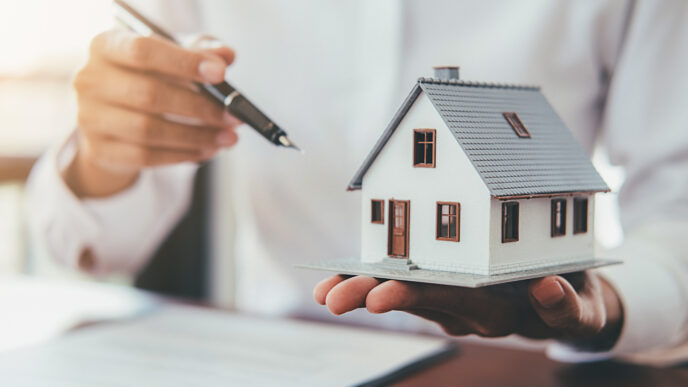 Real estate. Mano sostiene maqueta de casa y apunta a contrato. Crecimiento Proptech Xante en Inmobiliare Summits LATAM.