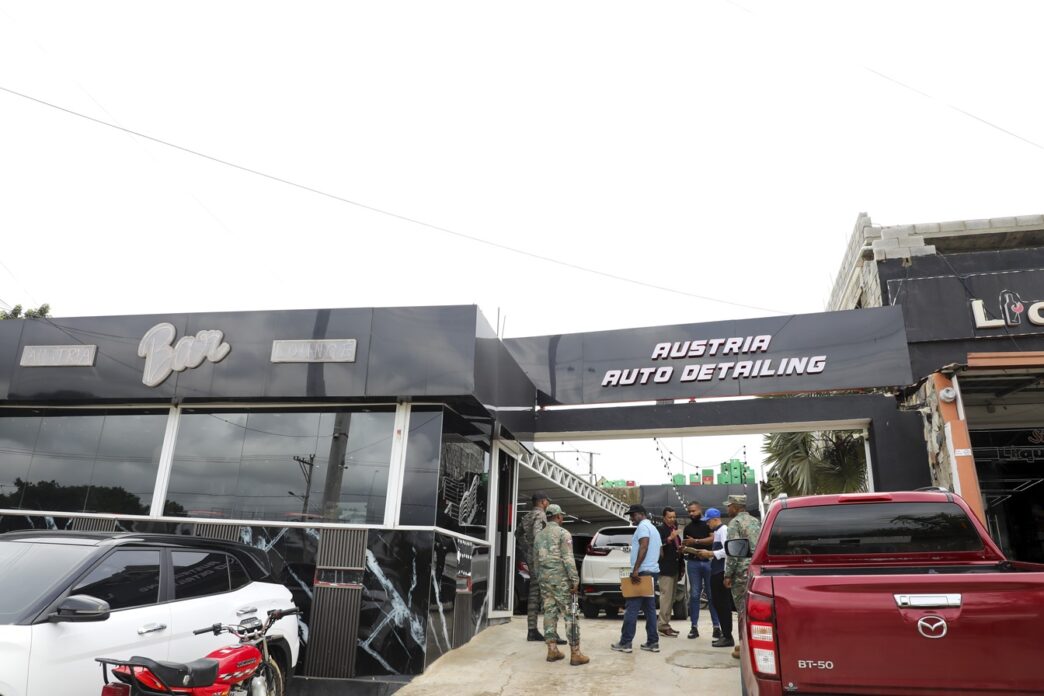 The image doesn't seem to be related to the keywords provided. I will provide an alt text based on the image content.

Exterior de Austria Auto Detailing y Bar, con personas y vehículos. Fachada moderna en blanco y negro.