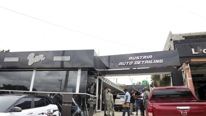 The image doesn't seem to be related to the keywords provided. I will provide an alt text based on the image content.

Exterior de Austria Auto Detailing y Bar, con personas y vehículos. Fachada moderna en blanco y negro.