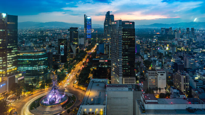 Vista nocturna de alcaldías CDMX con rentabilidad anual, mostrando edificios iluminados y el Ángel de la Independencia. Inversión en CDMX.