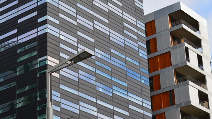 Edificios modernos de bienes raíces comerciales. Arquitectura contemporánea con fachadas de vidrio y acero reflejando el cielo. Inversión Estate.co