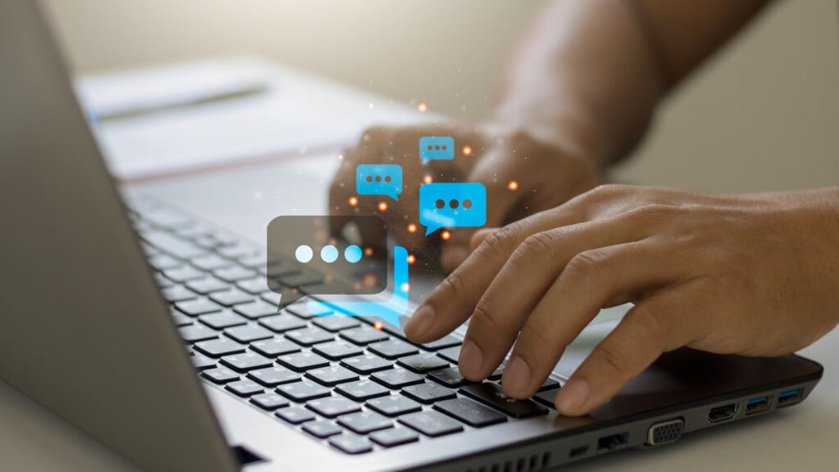 Ilustración digital de manos tecleando en laptop con burbujas de chat. Real estate y tecnología en conferencias Inmobiliare Summits LATAM.