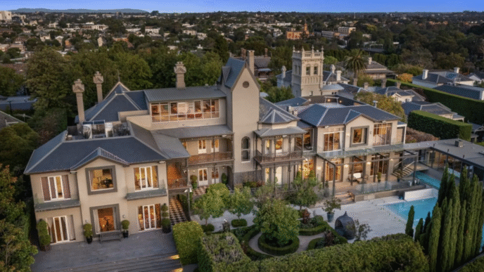 Vista aérea de exclusiva mansión en Toorak a la venta por $63 millones. Arquitectura impresionante, piscina y jardines exuberantes. Lujo y elegancia.