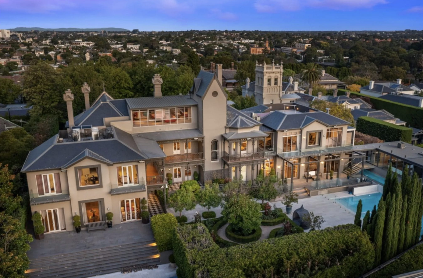 Vista aérea de exclusiva mansión en Toorak a la venta por $63 millones. Arquitectura impresionante, piscina y jardines exuberantes. Lujo y elegancia.