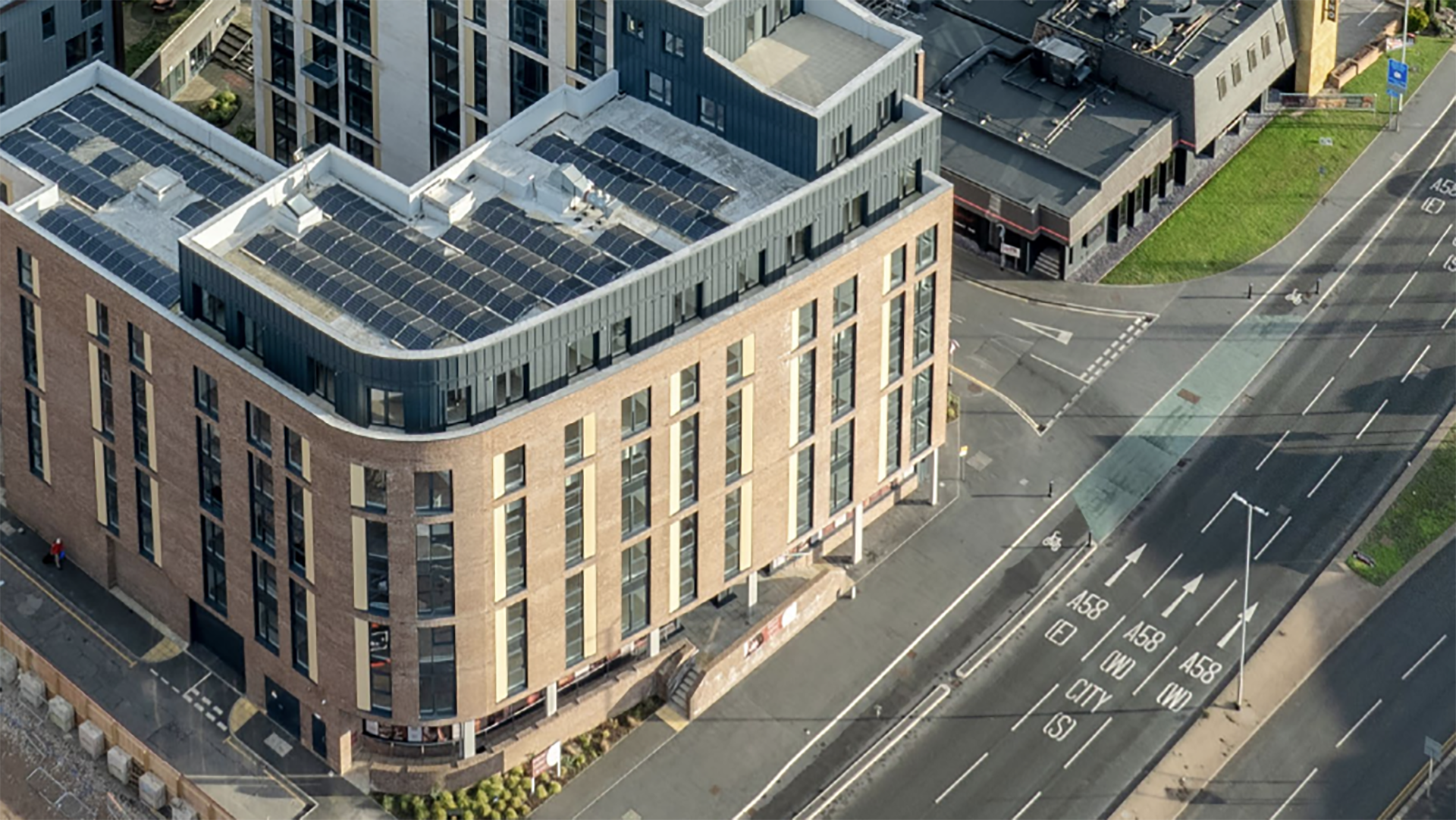 Vista aérea de edificio Build-to-Rent con paneles solares, reflejando la expansión de Starlight Investments en el mercado inmobiliario. Fachada moderna y vial.