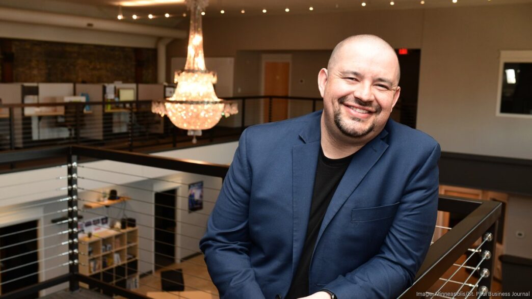 Hombre sonriendo en las instalaciones de Sonex Health en Minnesota. Expansión industrial impulsa el sector de tecnología médica innovadora en la región.