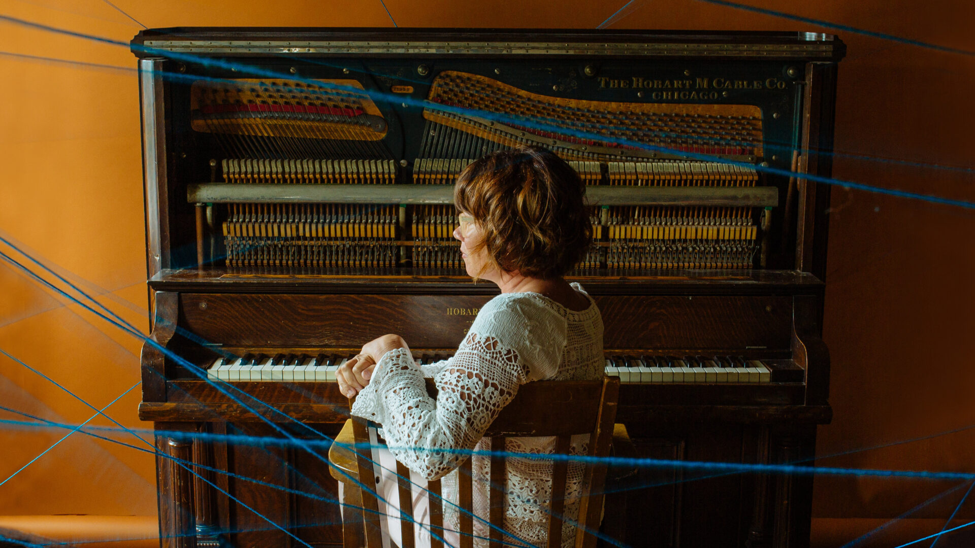 speakers/headshot
Retrato de perfil de una mujer sentada frente a un piano antiguo. Concepto musical. Inmobiliare Summits.