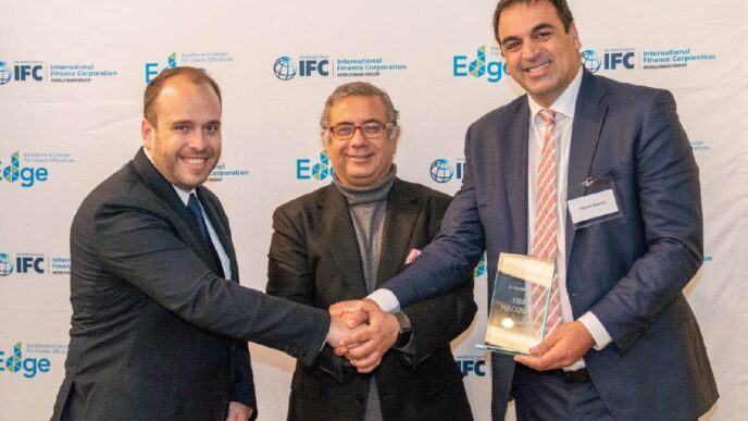 Entrega de certificación EDGE a Fibra Macquarie en Inmobiliare Summits. Speakers estrechan manos en evento de real estate en México.