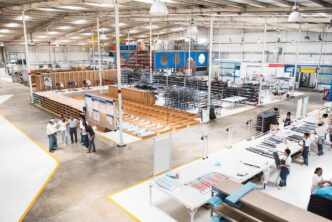 Vista aérea de una planta de manufactura tras la adquisición de Terrafina por Fibra Prologis. Operarios y estanterías muestran la actividad industrial.
