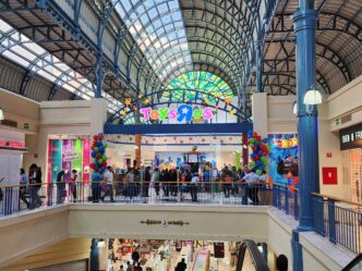 Venue/architecture.
Interior de centro comercial en México con tienda ToysRUs. Arquitectura moderna con techo de cristal. Espacio comercial concurrido.