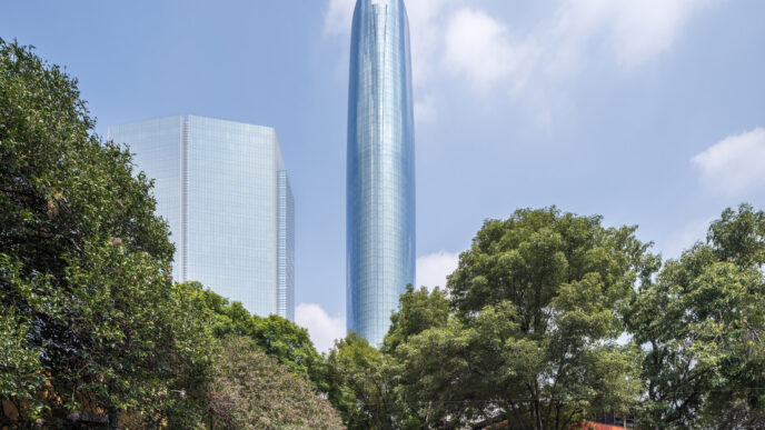 Vista del proyecto Mitikah, propiedad de Fibra Uno, destacando sus torres de usos mixtos contra un cielo azul y vegetación urbana. Arquitectura moderna.