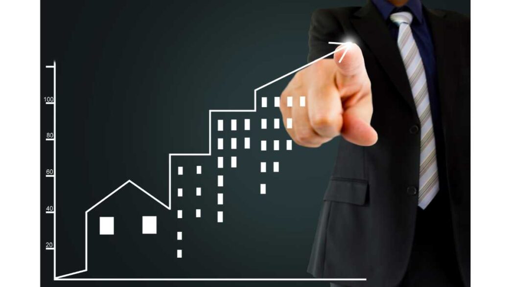 Gráfico de crecimiento inmobiliario con mano apuntando hacia arriba. Inversión en bienes raíces en México y LATAM.
