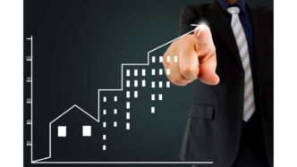 Gráfico de crecimiento inmobiliario con mano apuntando hacia arriba. Inversión en bienes raíces en México y LATAM.