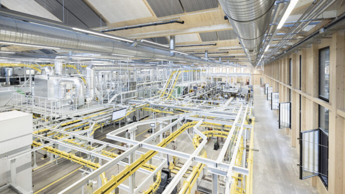 Vista aérea de planta industrial Metall Zug en Suiza, con maquinaria avanzada y sistemas de transporte. Impulso tecnológico visible en cada detalle.