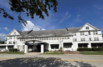 Fachada del proyecto de vivienda para seniors en Florida, con el nombre Crown Court visible. Financiado para impulsar el desarrollo inmobiliario.