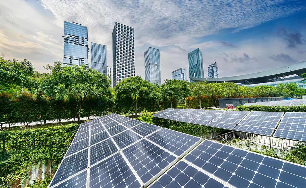 Paneles solares capturando energía renovable en un proyecto habitacional sostenible, con rascacielos de fondo. Finanzas verdes impulsan la iniciativa.