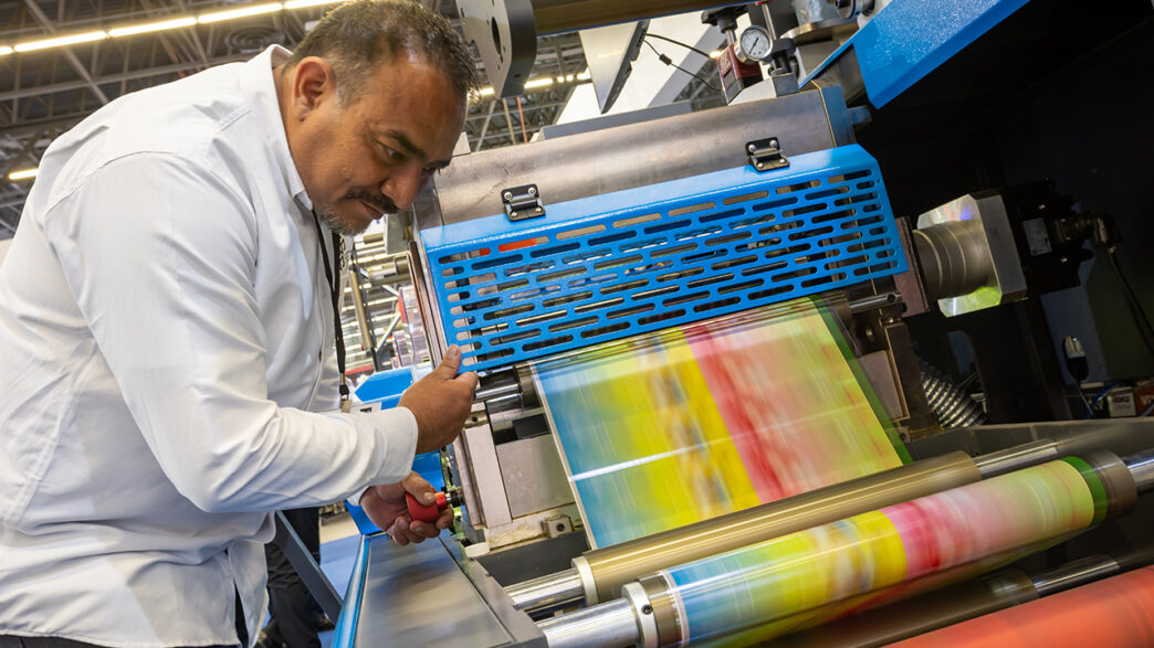 Networking/expo.

Visitante en la conferencia Inmobiliare Summits revisando una máquina de impresión durante un evento de real estate en México.