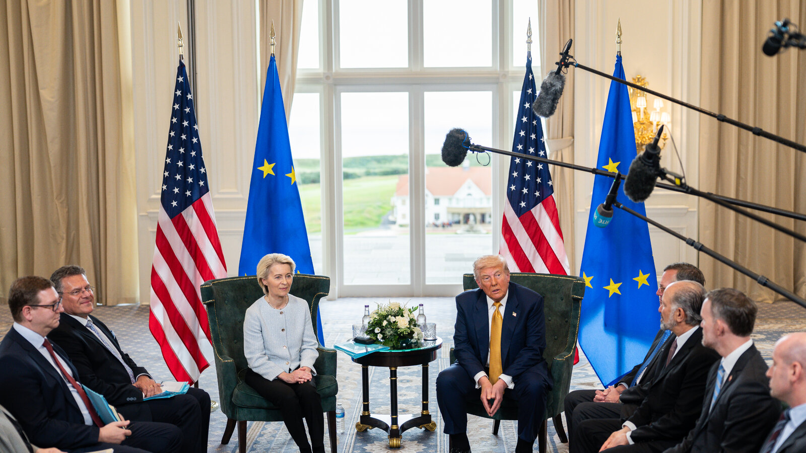 venue/architecture
Donald Trump y Ursula von der Leyen en una reunión. Banderas de EE. UU. y la UE de fondo. Reunión en un venue con luz natural.