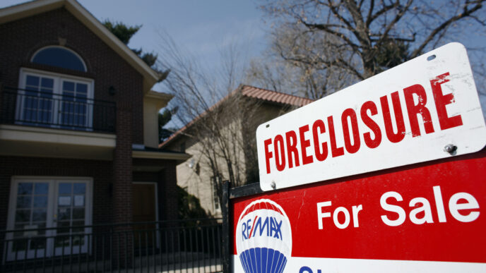 Cartel de 'Foreclosure' frente a una casa cerca de Columbia. Impacto en el mercado inmobiliario visible. Venta por RE/MAX. Crisis hipotecaria.