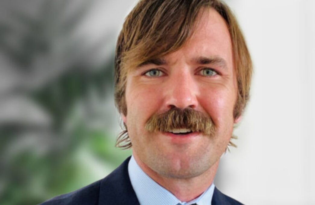 Retrato de ejecutivo de FRP Holdings, con bigote prominente, tras la adquisición de propiedades logísticas en Parsippany. Primer plano del rostro.