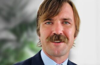 Retrato de ejecutivo de FRP Holdings, con bigote prominente, tras la adquisición de propiedades logísticas en Parsippany. Primer plano del rostro.