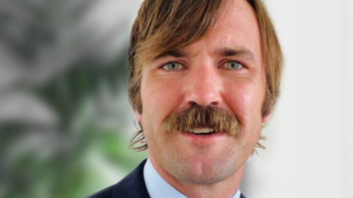 Retrato de ejecutivo de FRP Holdings, con bigote prominente, tras la adquisición de propiedades logísticas en Parsippany. Primer plano del rostro.