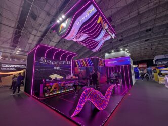 Stand en feria industrial con iluminación neón y logo Netinsight Sports. Diseño moderno e innovador para promoción de inmuebles industriales.