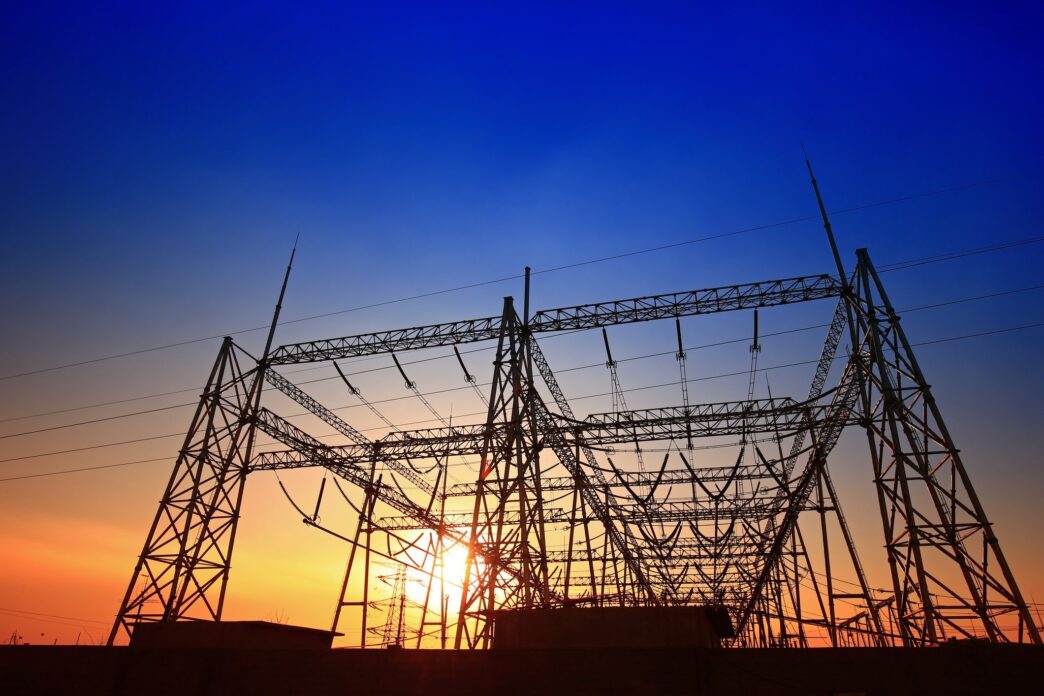 Silueta de líneas eléctricas al atardecer en Ohio, energía flexible de Gridmatic innovando con contratos energéticos. Alta tensión y cielo azul.