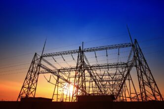 Silueta de líneas eléctricas al atardecer en Ohio, energía flexible de Gridmatic innovando con contratos energéticos. Alta tensión y cielo azul.