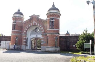 Entrada principal de la antigua prisión de Nara, ahora en construcción para ser Hotel Hoshinoya. Arquitectura histórica de ladrillo rojo con torres.