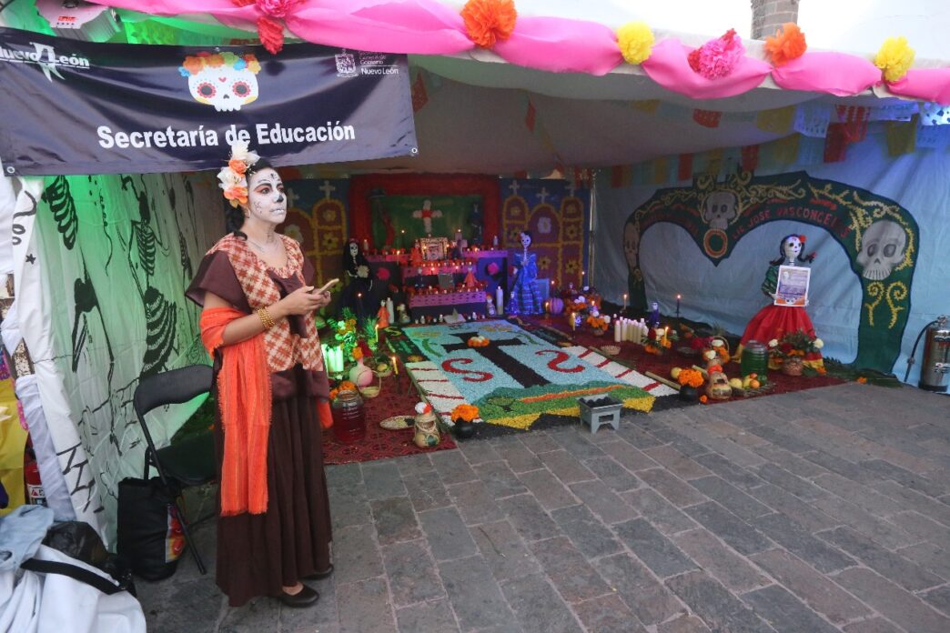 Sponsors/branding.

Altar del Día de Muertos, con ofrendas y decoraciones tradicionales. Banner de la Secretaría de Educación Nuevo León. Celebración en México.