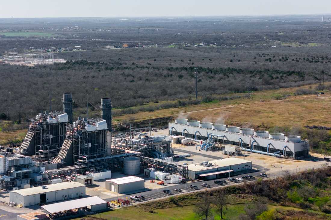 Vista aérea de un complejo de energía renovable de Houston American Energy, mostrando torres de enfriamiento y estructuras de generación de energía.