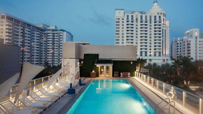 Vista de la piscina en la azotea del Iberostar Waves, con tumbonas y edificios urbanos al fondo. Iberostar Hotels & Resorts inaugura un nuevo hotel.