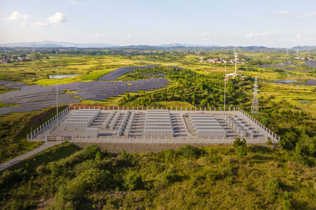 Vista aerea de almacenamiento energético para real estate sostenible. Baterías y paneles solares en campo verde.  Impacto en la energía renovable.
