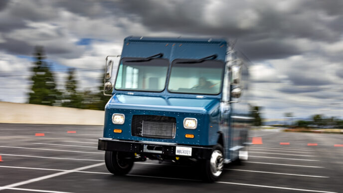 Camión eléctrico Harbinger en movimiento. Impacto vehículos eléctricos Harbinger en el sector Real Estate. Innovación y sostenibilidad en transporte.