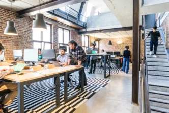 Espacio de trabajo moderno con gente en oficinas. Impacto del arrendamiento: diseño innovador para el mercado inmobiliario corporativo y coworking.