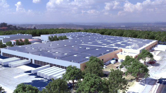 Vista aérea de un edificio con paneles solares en el techo, mostrando el impacto en la sostenibilidad inmobiliaria del sistema solar de UNFI.