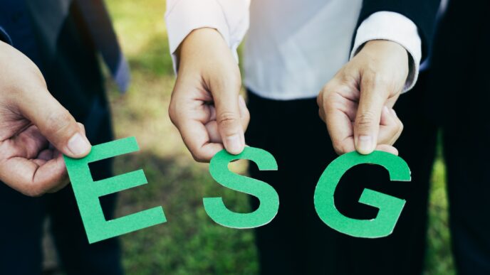Personas sosteniendo letras verdes 'ESG'. Impacto Rating ESG en valor Real Estate. Concepto de inversión sostenible y responsabilidad ambiental.