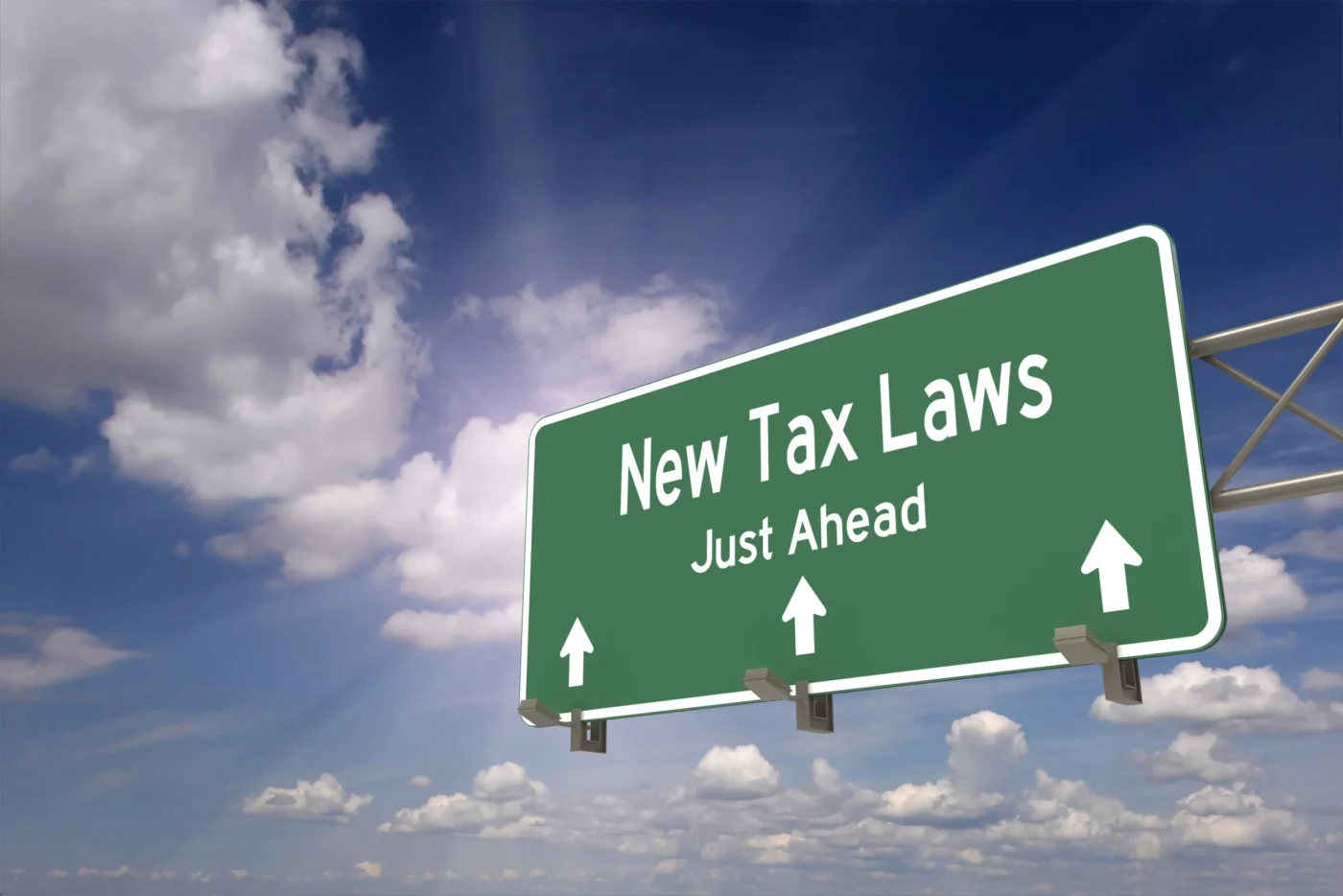 Señal de tráfico verde con texto "New Tax Laws Just Ahead" (Nuevas leyes fiscales más adelante), relevante para impuestos verdes y Real Estate.