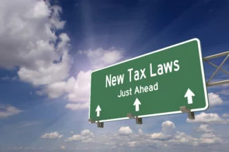 Señal de tráfico verde con texto "New Tax Laws Just Ahead" (Nuevas leyes fiscales más adelante), relevante para impuestos verdes y Real Estate.