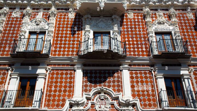 Fachada de vivienda tradicional poblana con azulejos rojos y balcones, proyecto reconocido por INAH Puebla. Arquitectura colonial en Puebla.