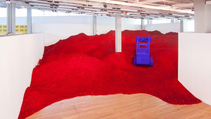 Instalación artística con polvo rojo y objeto azul en Inflexiones Querétaro, evento de arquitectura y urbanismo mundial. Diseño y color contrastante.