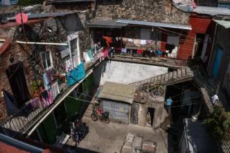 Patio vecinal con ropa tendida en viviendas. Infonavit y renta de inmuebles visibles. AMLO propone construir viviendas para el pueblo mexicano.