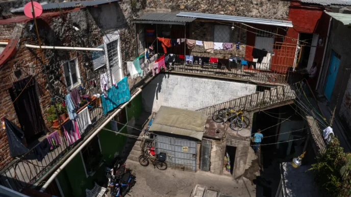 Patio vecinal con ropa tendida en viviendas. Infonavit y renta de inmuebles visibles. AMLO propone construir viviendas para el pueblo mexicano.