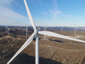Vista aérea del Parque Eólico de Baja California Fase II con aerogeneradores sobre colinas, cielo azul y energía renovable. Producción de energía eólica.