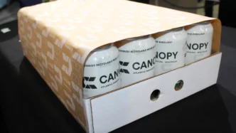 Innovador embalaje de poliéster de alto rendimiento mostrando latas de bebidas 'Canopy' en empaque reciclable. Solución de embalaje moderna y sostenible.