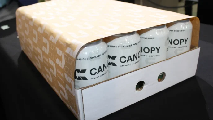 Innovador embalaje de poliéster de alto rendimiento mostrando latas de bebidas 'Canopy' en empaque reciclable. Solución de embalaje moderna y sostenible.