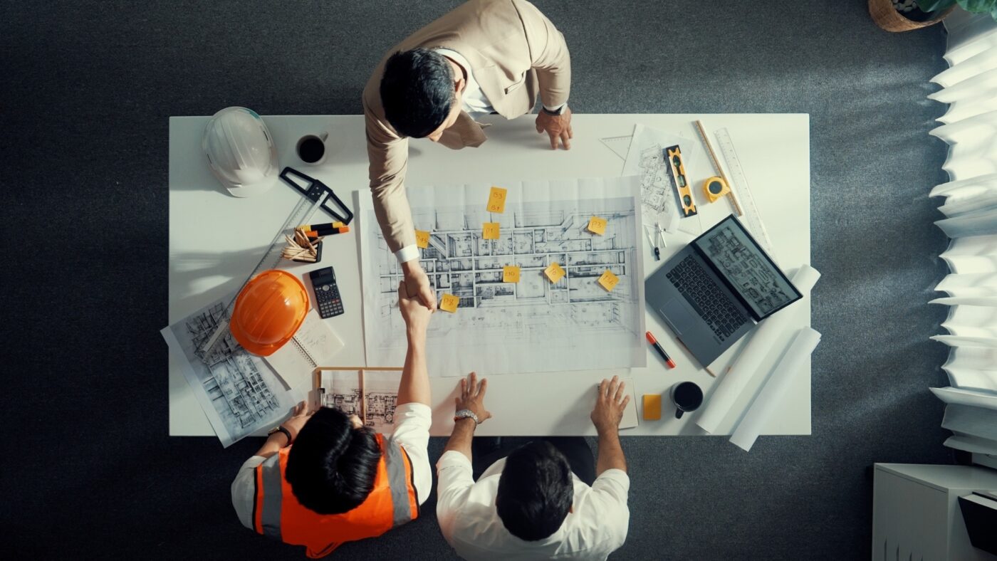 Venue/architecture.

Socios colaboran en planos de construcción. Reunión de expertos en bienes raíces, discutiendo estrategias para Inmobiliare Summits LATAM.