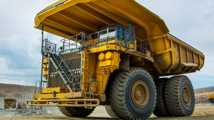 Camión minero eléctrico Komatsu amarillo en mina. Innovación y sostenibilidad en la minería con vehículos eléctricos de gran tonelaje.